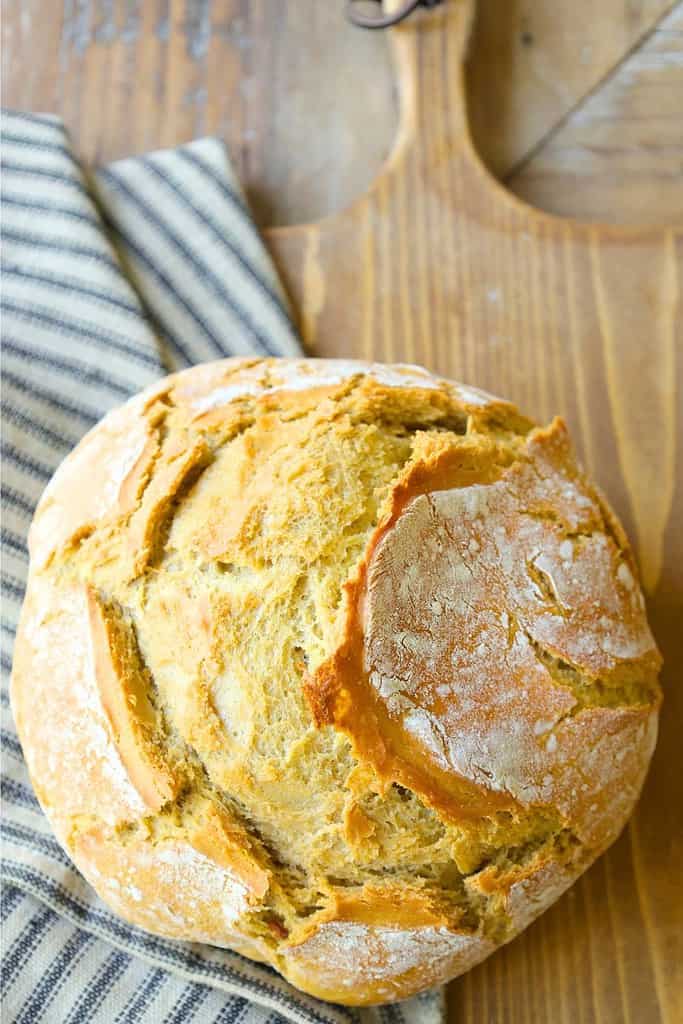 lazy-sourdough-bread-on-a-french-bread-board-next-to-striped-towel