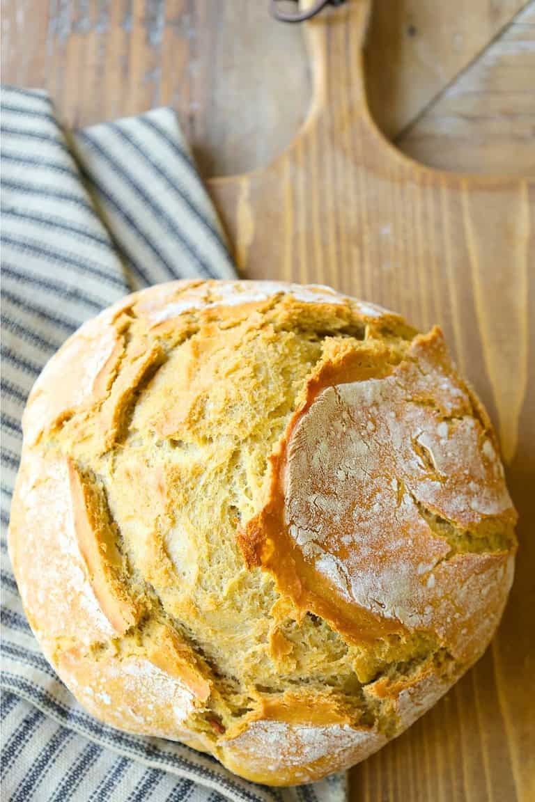 lazy-sourdough-bread-on-a-french-bread-board-next-to-striped-towel