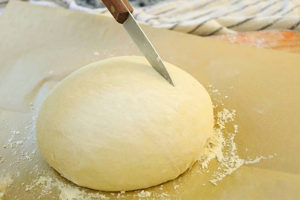 slashing-the-dough-ball-with-wooden-knife